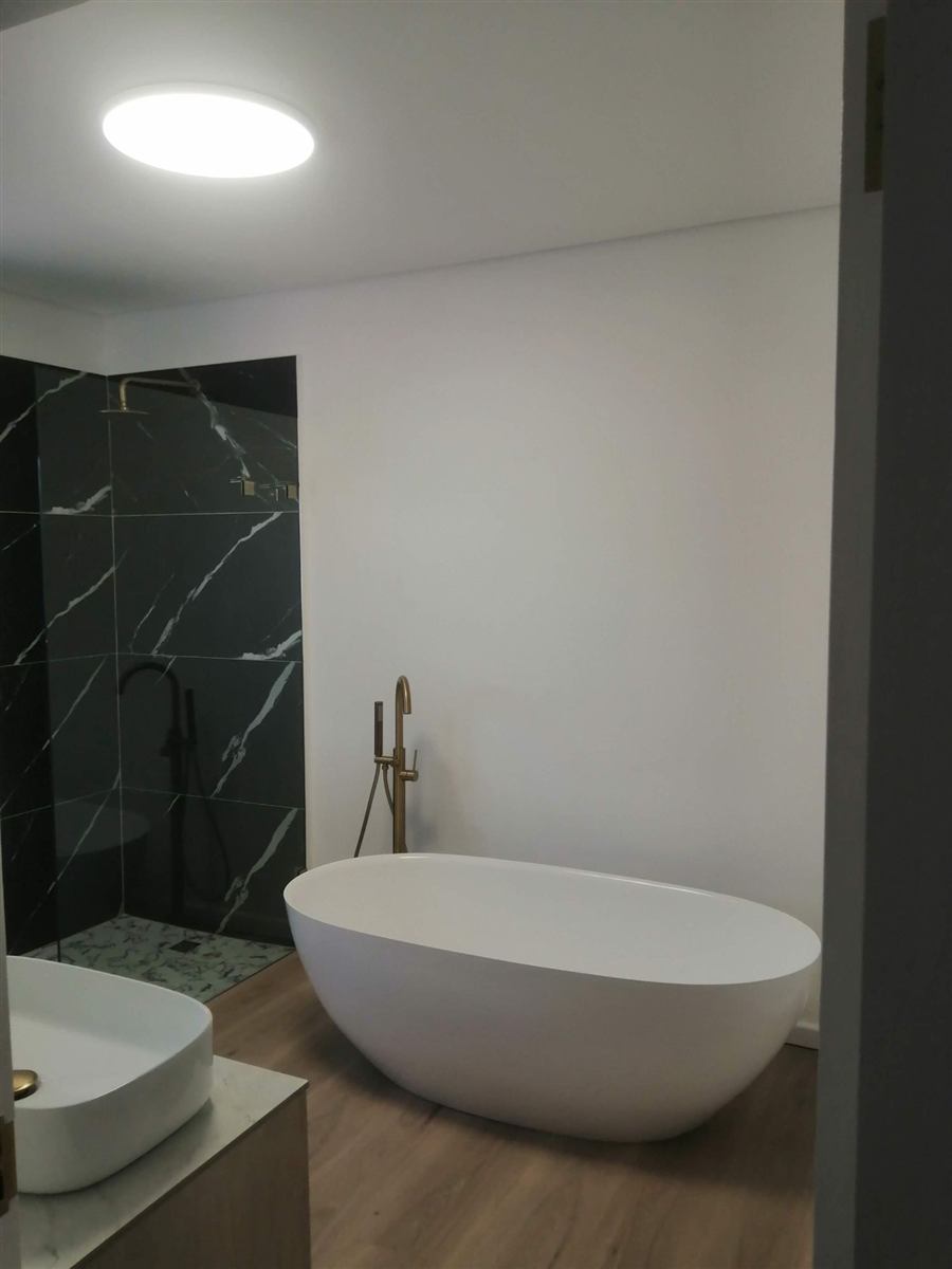 Bathroom with a freestanding bath and a slim round LED ceiling light