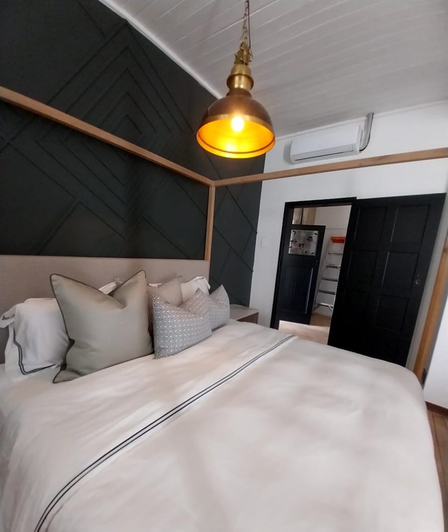 Bedroom with a brass dome pendant light over the bed