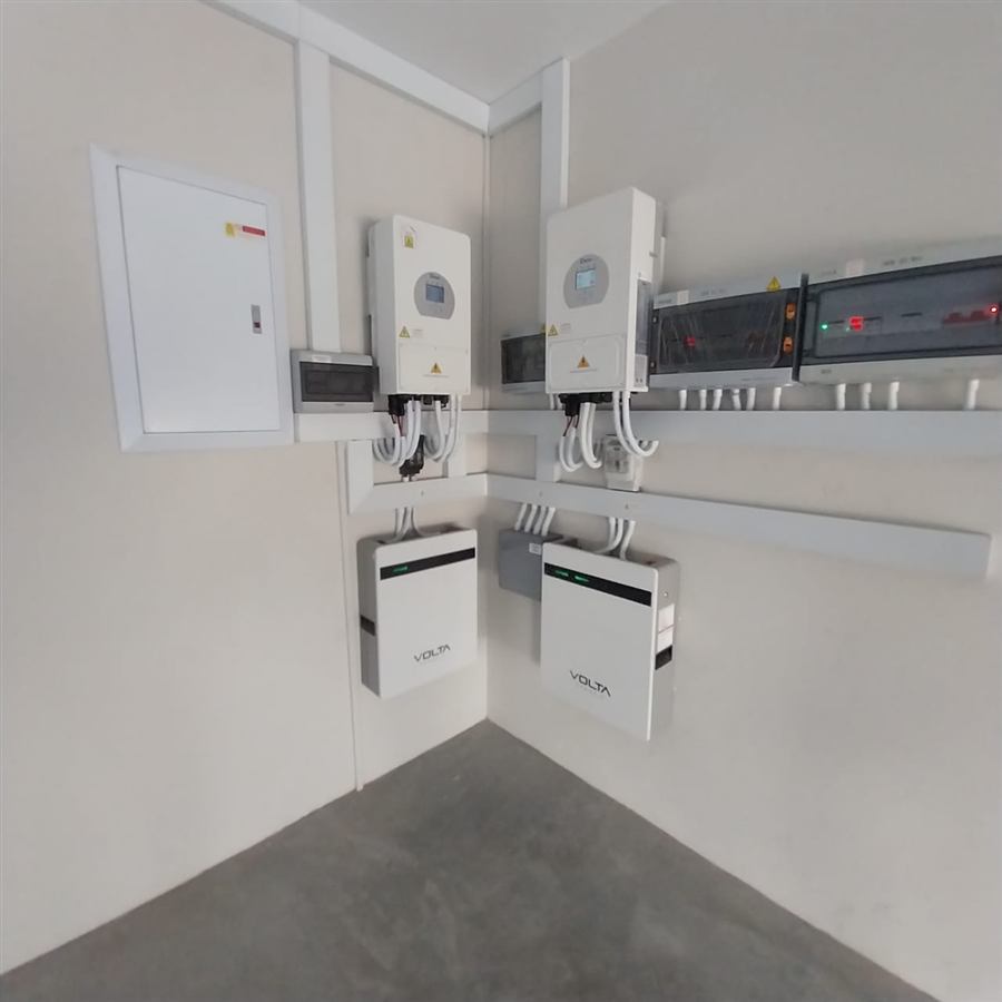 Plant room with two hybrid inverters, two wall-mounted batteries and DB boards, cabled neatly through white trunking